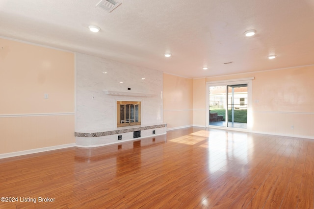 unfurnished living room featuring light wood finished floors, visible vents, and a wainscoted wall