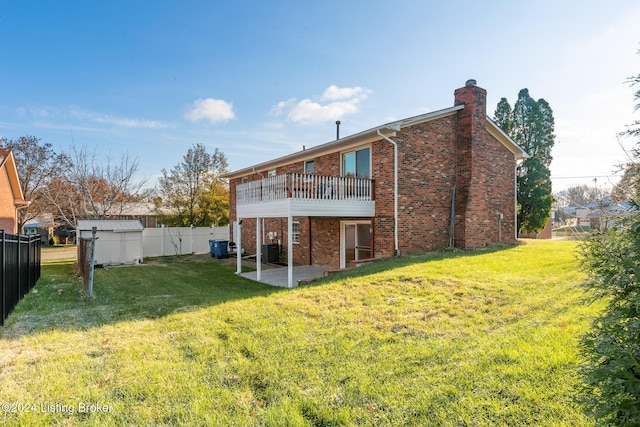 back of property with a patio area, brick siding, a yard, and a fenced backyard