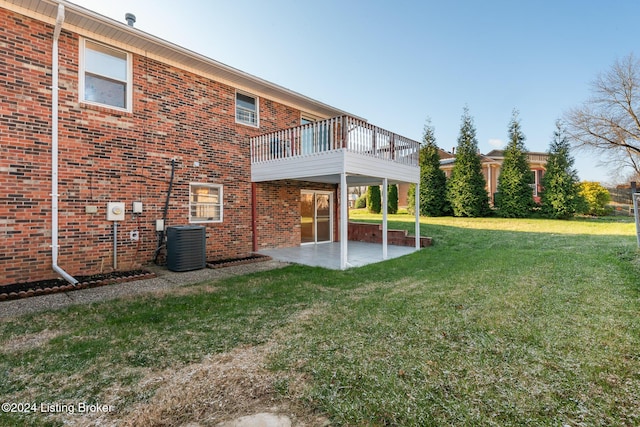 back of property with brick siding, a lawn, a patio, and central air condition unit