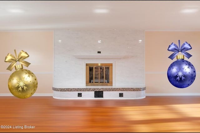 interior details featuring a tile fireplace, baseboards, and wood finished floors