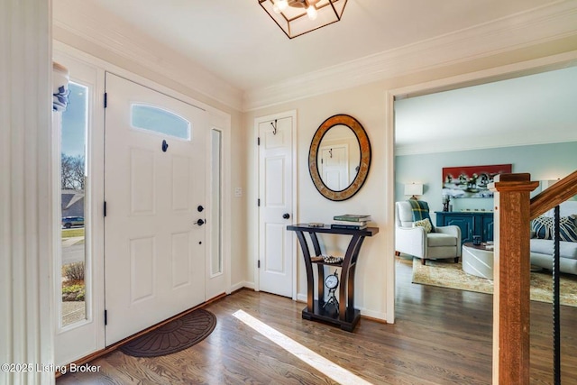 entrance foyer with crown molding, stairway, baseboards, and wood finished floors