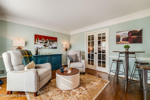 sitting room with visible vents, ornamental molding, wood finished floors, and french doors