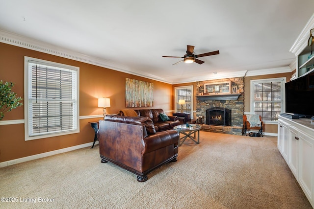 living area featuring light carpet, baseboards, ceiling fan, crown molding, and a fireplace