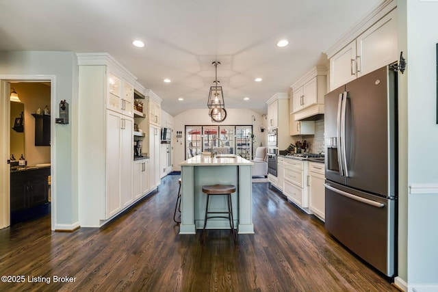 kitchen featuring white cabinets, dark wood-style floors, appliances with stainless steel finishes, and vaulted ceiling