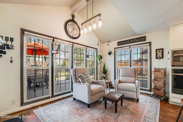 living area with high vaulted ceiling, a wealth of natural light, beamed ceiling, and wood finished floors