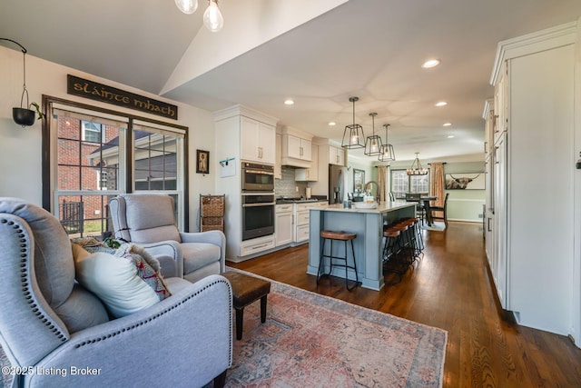 living room with dark wood-type flooring, recessed lighting, and a healthy amount of sunlight