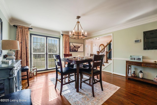 dining area with ornamental molding, dark wood-style flooring, an inviting chandelier, and stairs