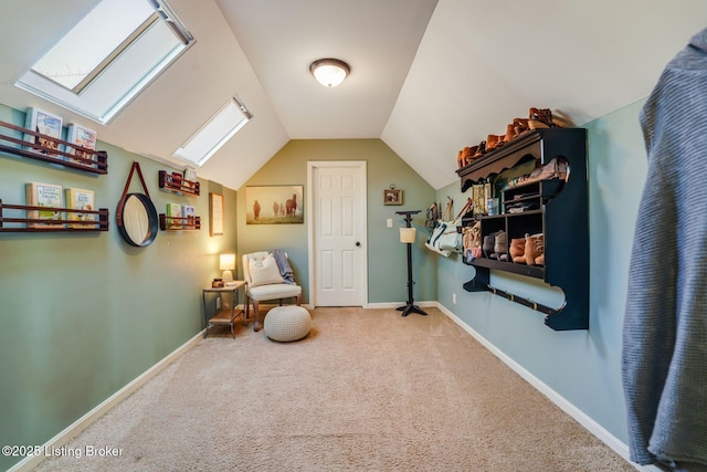 living area featuring carpet, vaulted ceiling with skylight, and baseboards