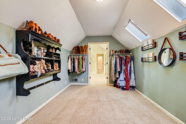 spacious closet with vaulted ceiling with skylight, carpet floors, and visible vents