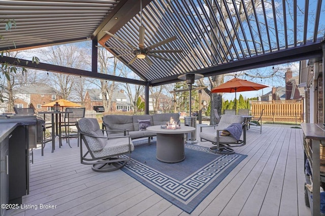 wooden deck with ceiling fan and an outdoor living space with a fire pit