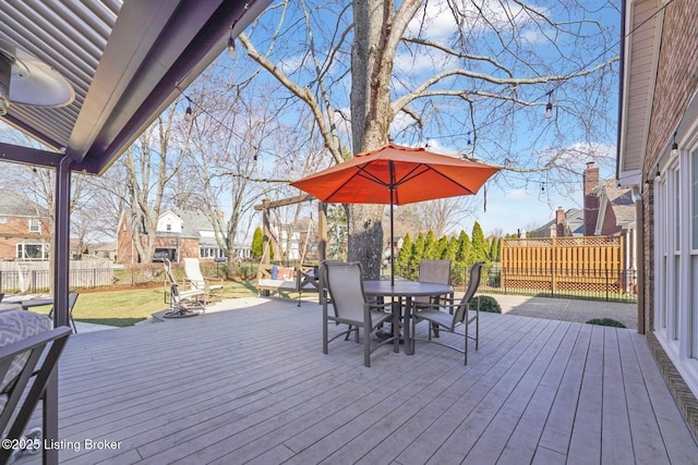 wooden terrace with outdoor dining space and fence