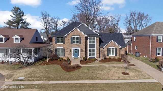 view of front facade with brick siding and a front lawn