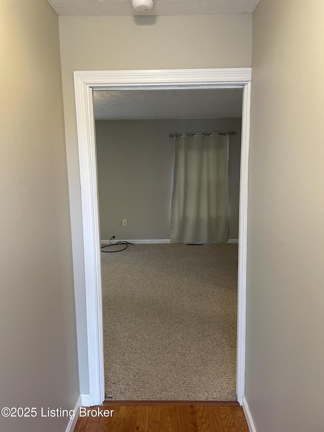 hall with carpet and baseboards