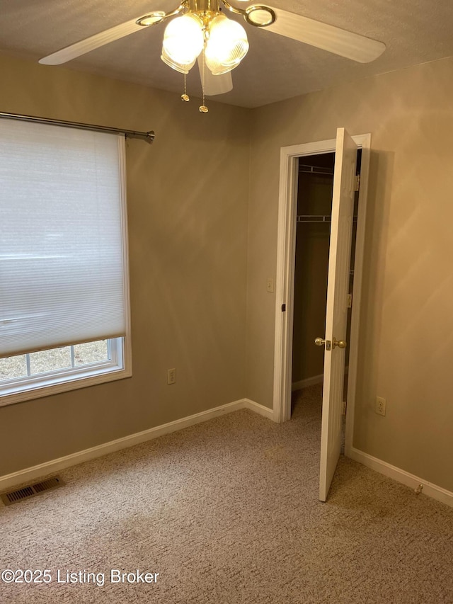 unfurnished bedroom with carpet floors, a closet, visible vents, and a ceiling fan