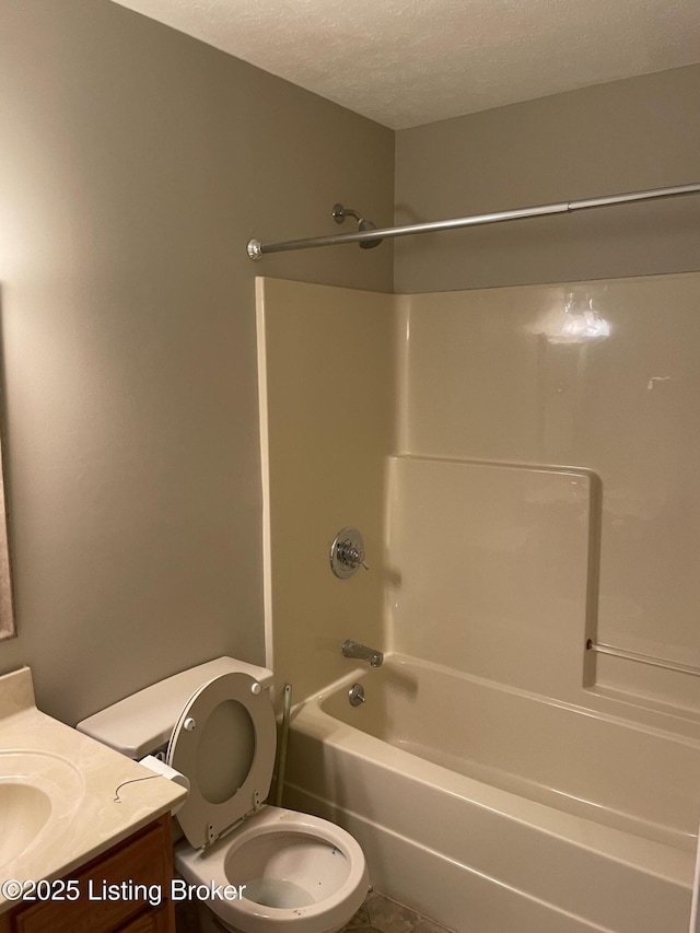 full bathroom featuring toilet, shower / bathing tub combination, a textured ceiling, and vanity