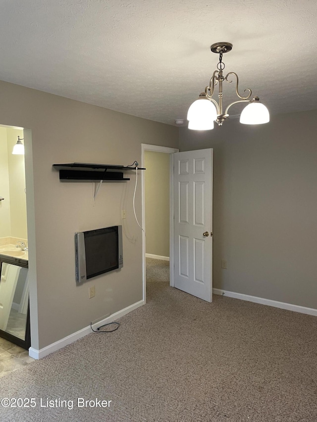 unfurnished living room with carpet, a sink, and baseboards