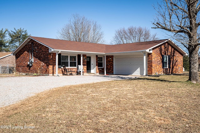 single story home with brick siding, covered porch, a garage, driveway, and a front lawn