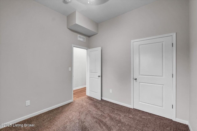 unfurnished bedroom featuring visible vents, baseboards, and carpet flooring