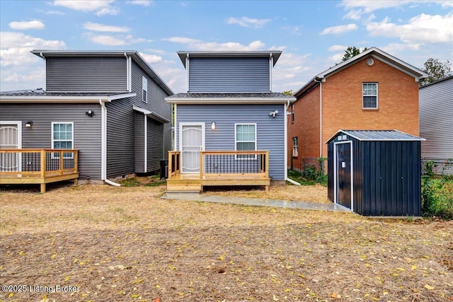 rear view of property with a storage shed, an outbuilding, and a wooden deck