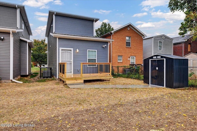 back of house with a shed, a wooden deck, and an outbuilding