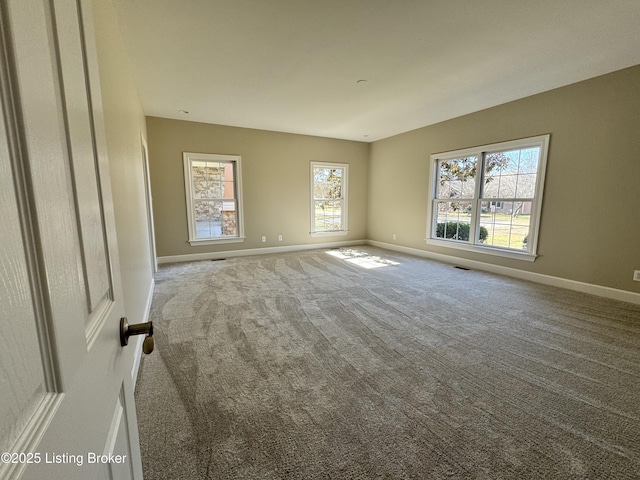 carpeted spare room with baseboards