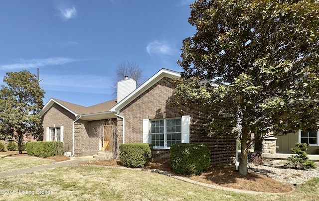 ranch-style home featuring a front lawn, brick siding, and a chimney