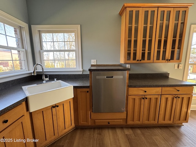 kitchen featuring dark countertops, a sink, brown cabinets, and stainless steel dishwasher