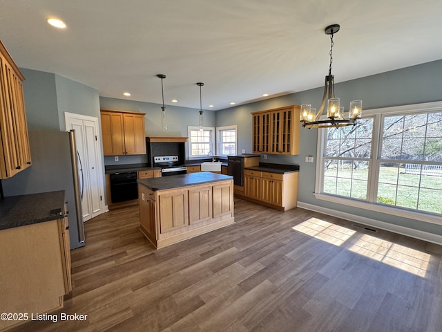 kitchen with dark wood-style floors, electric range, a sink, dark countertops, and black oven