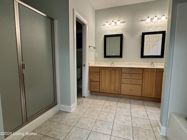 full bath featuring tile patterned floors, a stall shower, and a sink