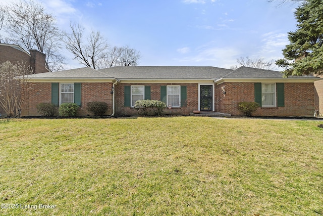 ranch-style home featuring brick siding, a chimney, and a front lawn