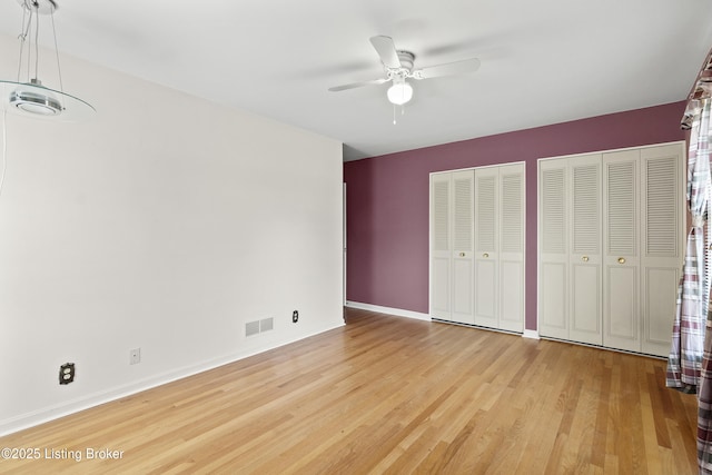3004 Brownsboro Vista Dr, Louisville, KY 40242 - unfurnished bedroom with wood finished floors, visible vents, baseboards, ceiling fan, and two closets