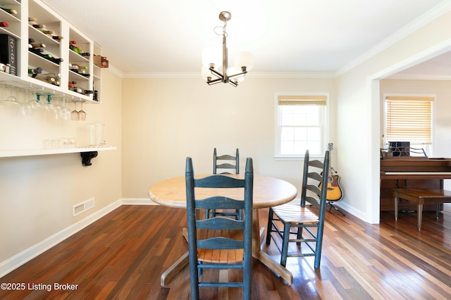 dining room featuring ornamental molding, dark wood finished floors, baseboards, and an inviting chandelier