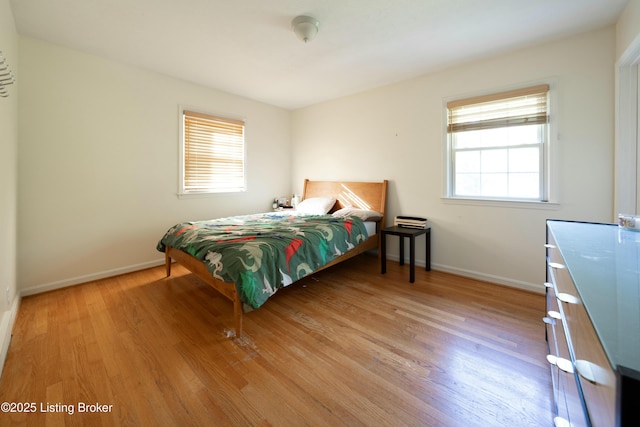 bedroom with light wood-type flooring and baseboards