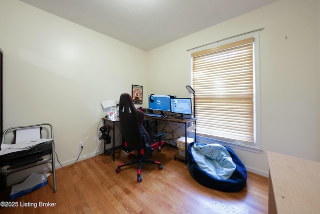 office area with a healthy amount of sunlight, baseboards, and wood finished floors