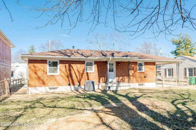 back of house with a gate, fence, a yard, central air condition unit, and brick siding