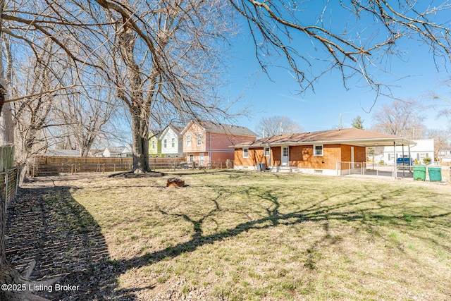 back of property featuring a yard, brick siding, and a fenced backyard