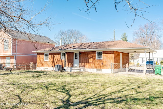 back of house with an attached carport, central AC, brick siding, fence, and a yard