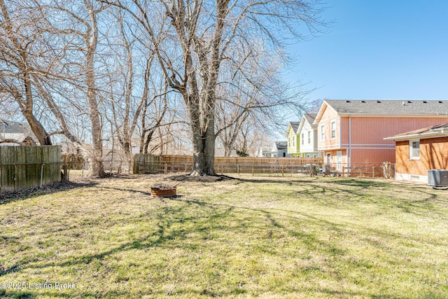 view of yard with a fenced backyard and central AC