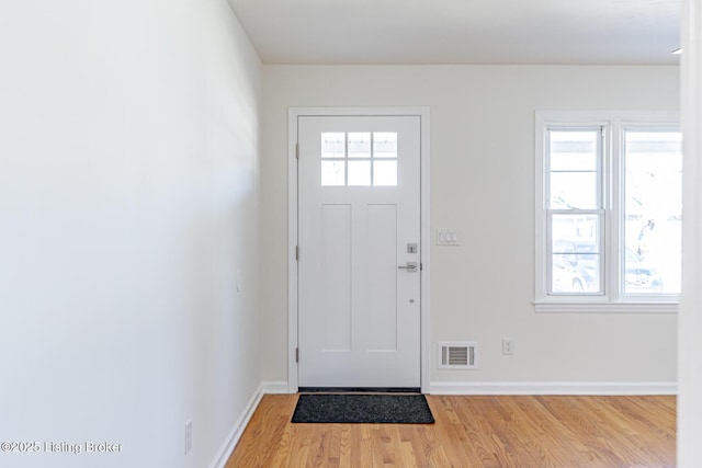 entrance foyer with wood finished floors, visible vents, and baseboards