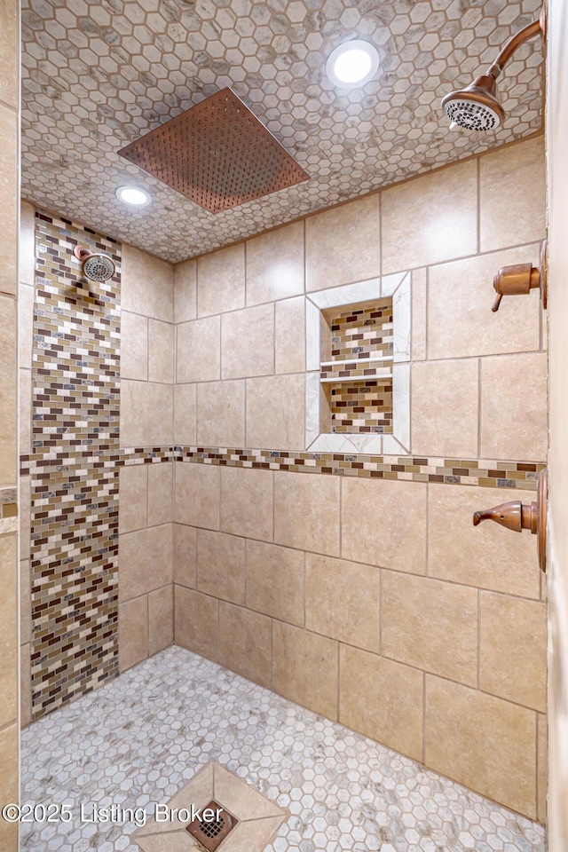 bathroom with a tile shower and recessed lighting