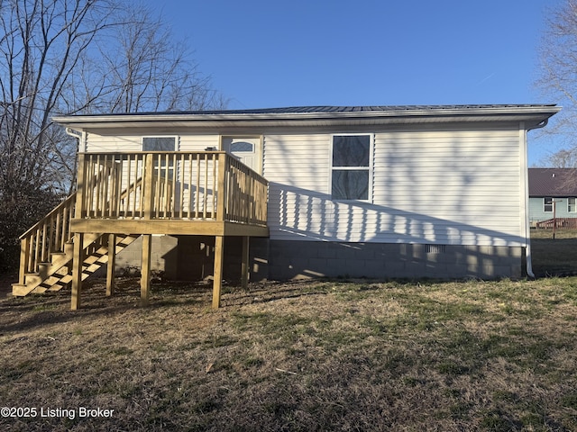 back of property featuring stairs, a deck, and a lawn