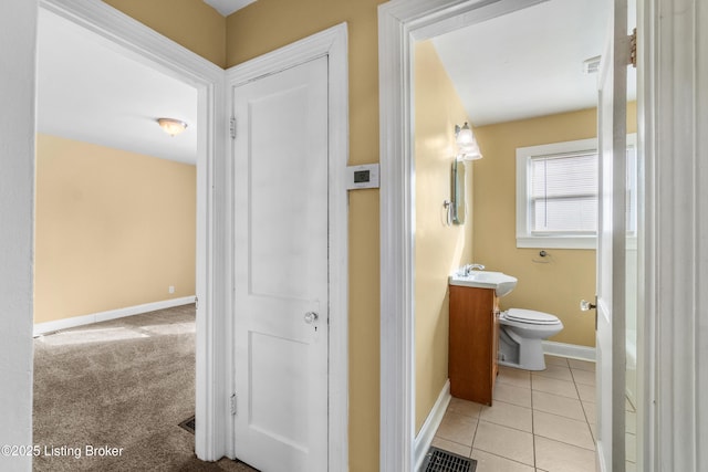 bathroom with baseboards, vanity, toilet, and tile patterned floors