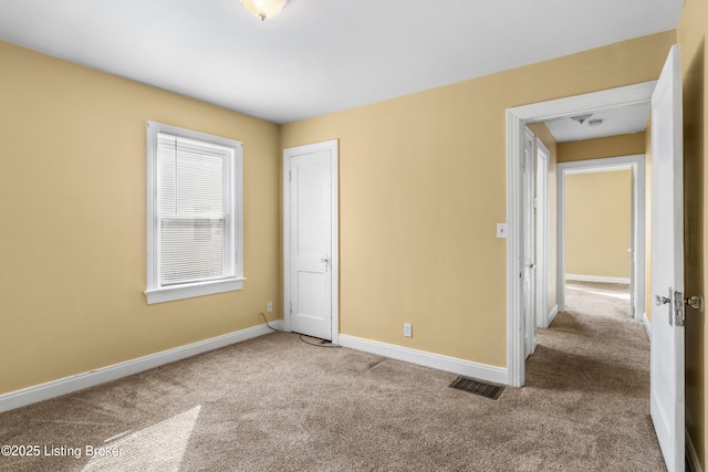 unfurnished bedroom featuring carpet, visible vents, and baseboards