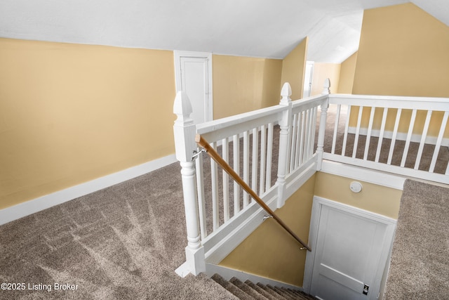 stairs featuring carpet flooring, vaulted ceiling, and baseboards