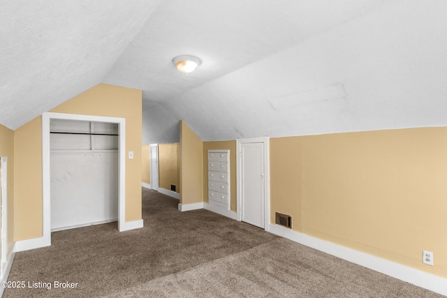 bonus room featuring baseboards, visible vents, lofted ceiling, a textured ceiling, and carpet flooring