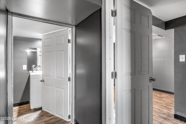 corridor with wood finished floors and baseboards