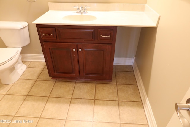 bathroom with toilet, tile patterned flooring, baseboards, and vanity