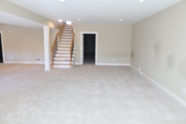 unfurnished room with light carpet, stairway, and baseboards