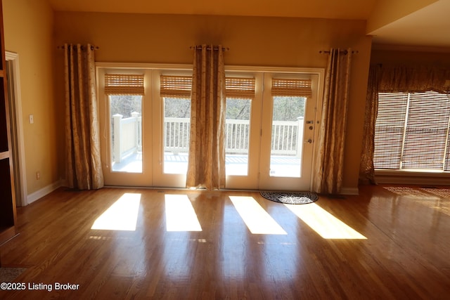 doorway to outside with french doors, wood finished floors, and baseboards