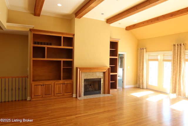 unfurnished living room featuring vaulted ceiling with beams, recessed lighting, a high end fireplace, light wood-type flooring, and baseboards